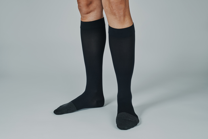 Chaussettes de contention noires portées jusqu'au genou, jambes d'homme