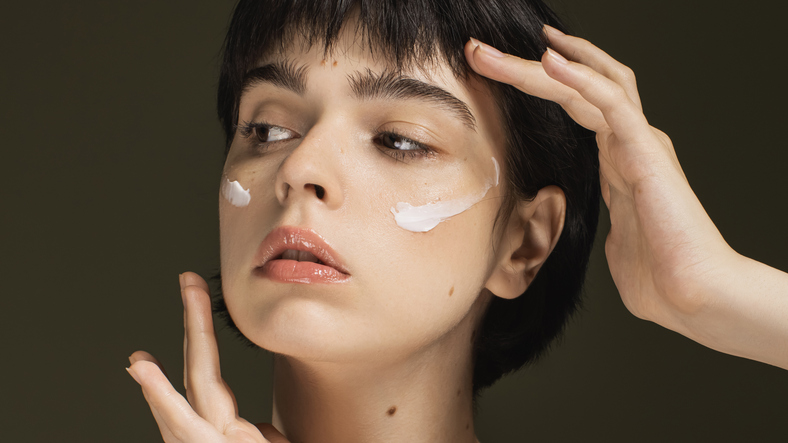 Femme appliquant une crème sur ses pommettes, portrait rapproché